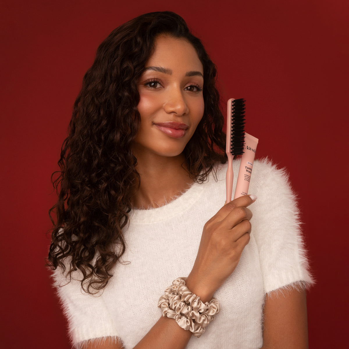 KITSCH Sleigh All Day 5pc Gift Set — lifestyle shot, model holding the Taming Wand and Styling Brush with Ruched Satin Scrunchies on her wrist — helps tame flyaways and frizz without stiffness or flakes — polished festive styling in seconds