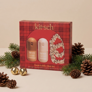 KITSCH Sweet & Silky Hair 4pc Set — red plaid gift box with the Caramel Cream and Warm Sugar mini hair perfumes and champagne satin scrunchies, styled with pine branches, pinecones and gold jingle bells on a cream backdrop — the season's cutest accessories — find a little something special for everyone on your list