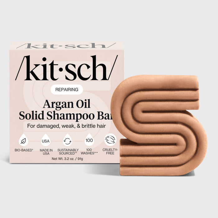 KITSCH Repairing Argan Oil Shampoo Bar — hero product shot on light gray background — REPAIRING Argan Oil Solid Shampoo Bar retail box with S-shaped bar — For damaged, weak, & brittle hair — Bio-based | Made in USA | 100 Washes | Cruelty-Free — Net Wt. 3.2 oz / 91g — Formulated with Everbond® to help reverse and repair hair damage